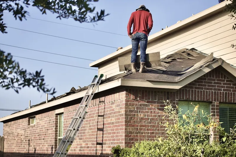 Professional roofer working on a residential roof in Gray